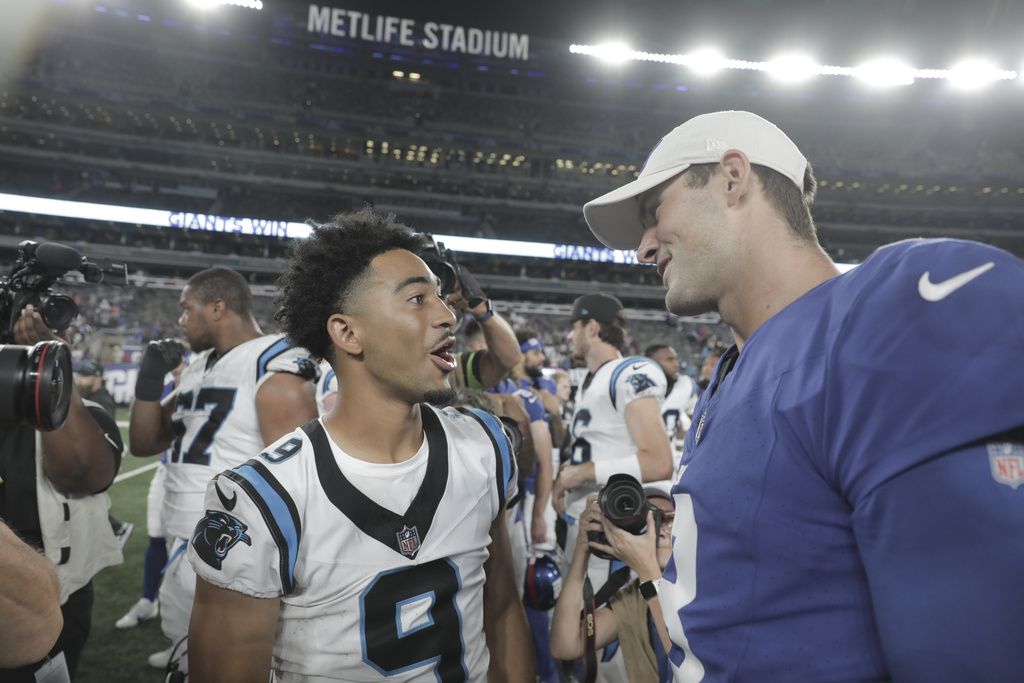 Carolina Panthers quarterback Bryce Young, left, greets New York Giants quarterback Daniel...