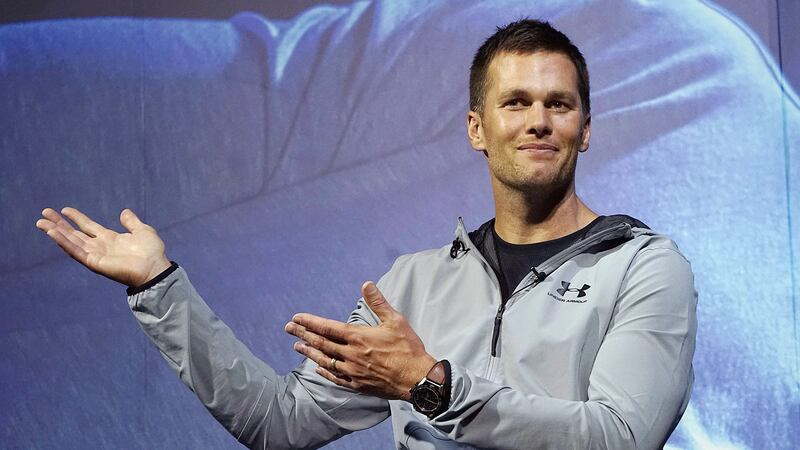 FILE - New England Patriots quarterback Tom Brady gestures during a promotional event, June...