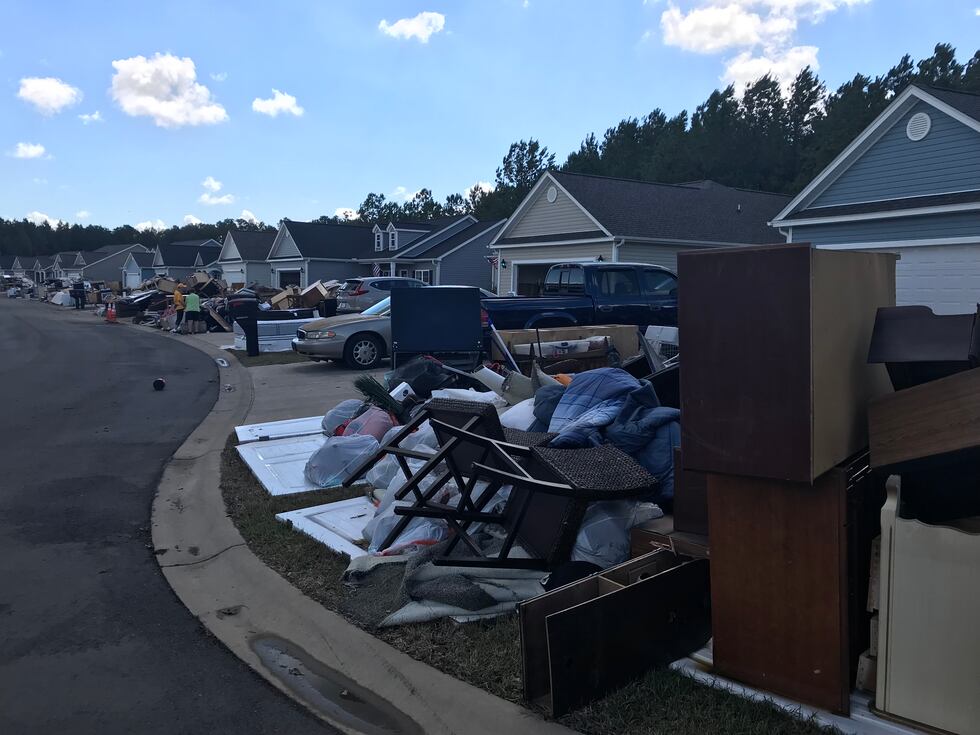 Belongs line the curbs in the Polo Farms neighborhood after extreme flooding damaged homes.